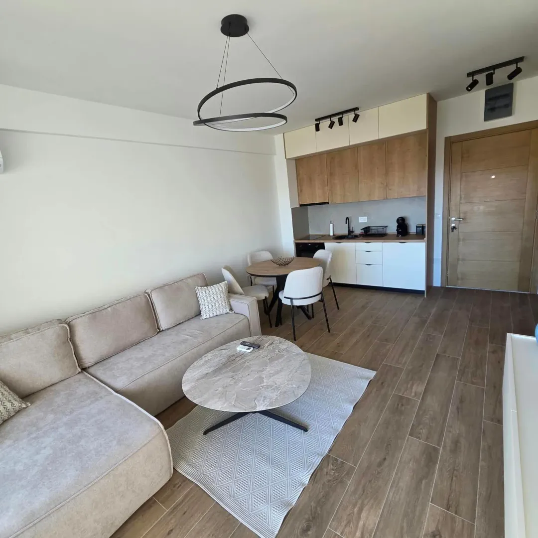 Living room with a sectional sofa, dining area, and kitchen in an open-plan layout.