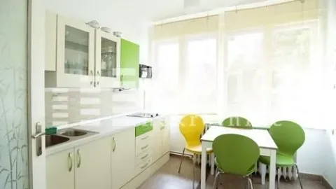 Bright kitchen with dining area and green details. - image 3