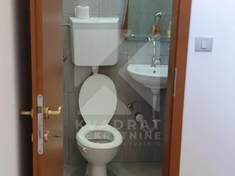 View of the bathroom with a toilet and washbasin through the open door. - image 2