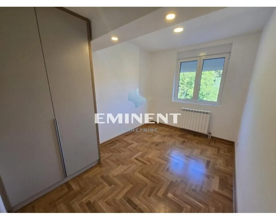Empty room with a built-in wardrobe and hardwood flooring.