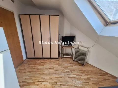 Attic room with wooden flooring, a large wardrobe, and a skylight. - image 3