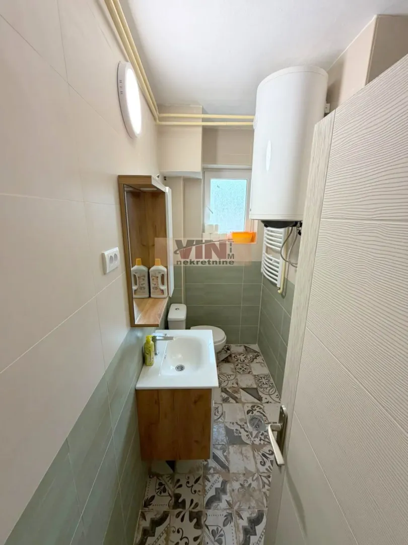 Manje kupatilo sa umivaonikom, wc šoljom, bojlerom i tuš kabinom.
