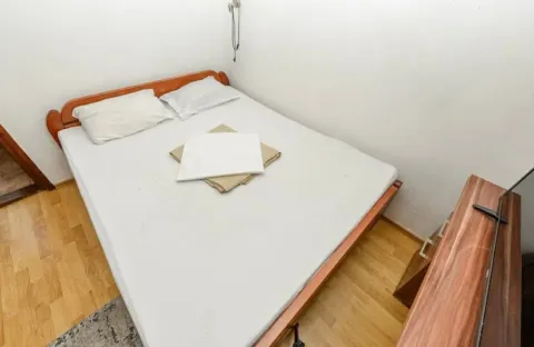 Small bedroom with a double bed and wooden flooring. - image 11