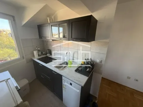 Smaller kitchen with dark cabinets and a white countertop. - image 3