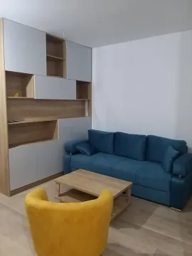 Living room with a blue sofa, a yellow armchair, and a wooden coffee table. - image 10