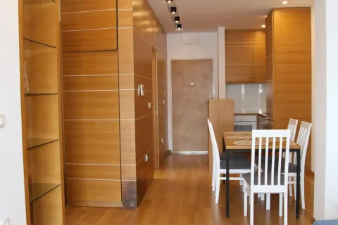 Dining area with wooden elements and a built-in kitchen in the background. - image 18