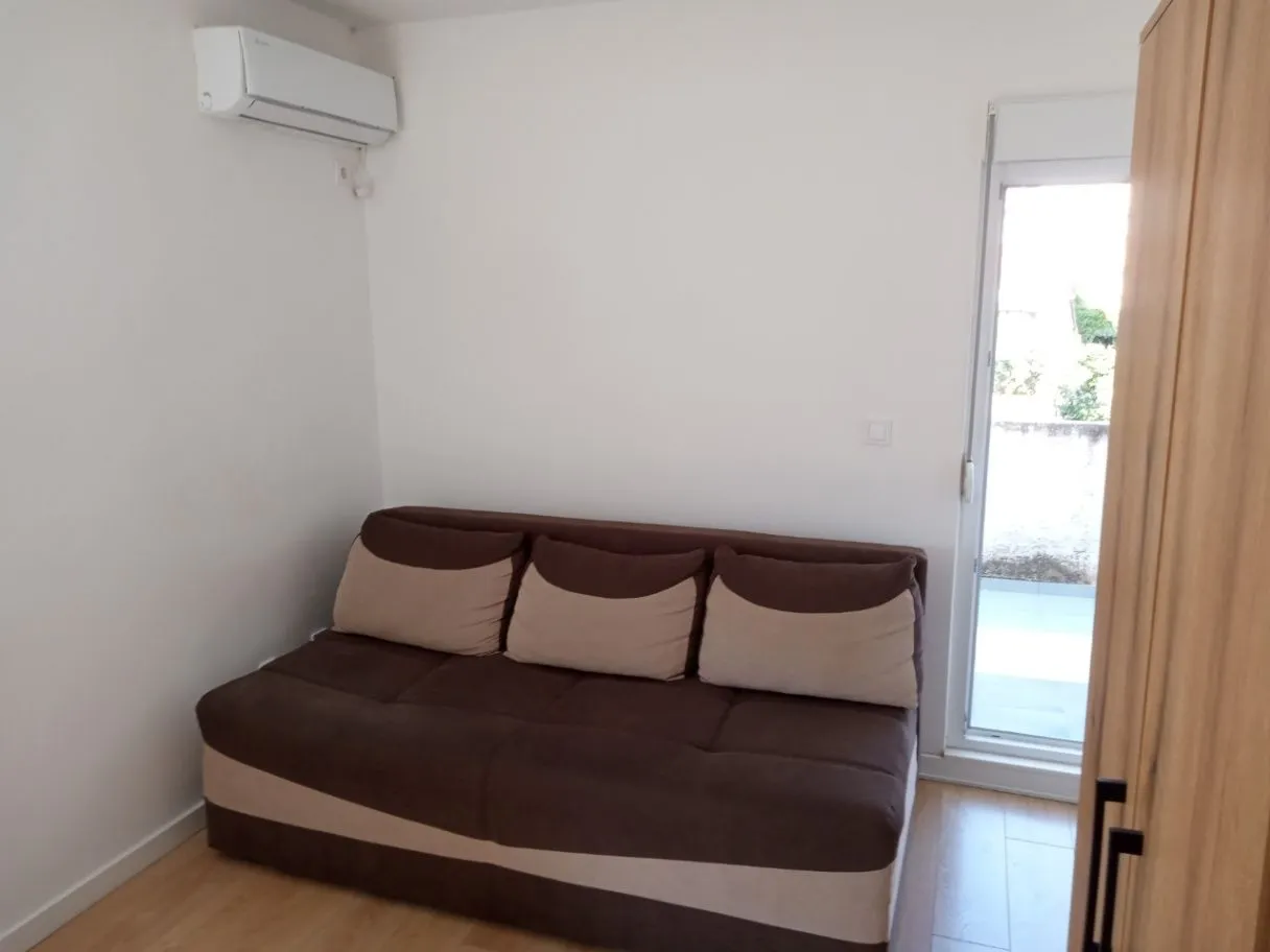 Smaller bedroom with a double sofa bed, air conditioning, and access to the terrace.