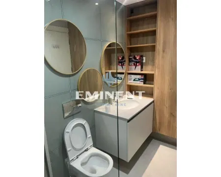 Modernly equipped bathroom with a washbasin, toilet, and wooden elements. - image 11