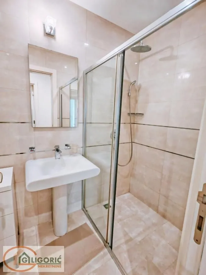 Bathroom equipped with a washbasin and a walk-in shower with a glass screen.