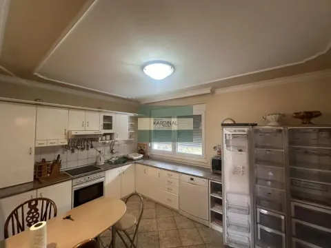 Kuhinja sa belim elementima, trpezarijskim stolom i frižiderom. - image 5