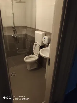 Smaller bathroom with a shower cabin, toilet bowl, and sink. - image 2