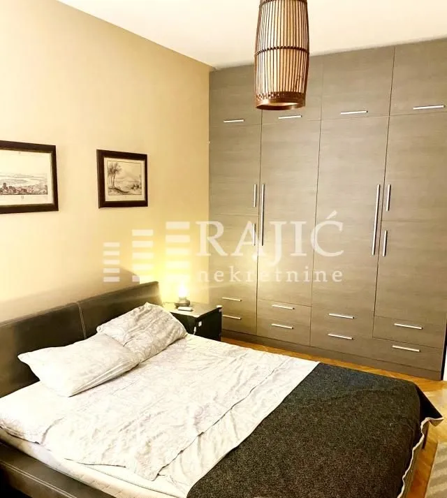 Bedroom with a double bed, large wardrobe, and a chandelier.