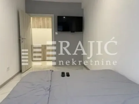 Furnished bedroom with a double bed and wall-mounted TV. - image 9