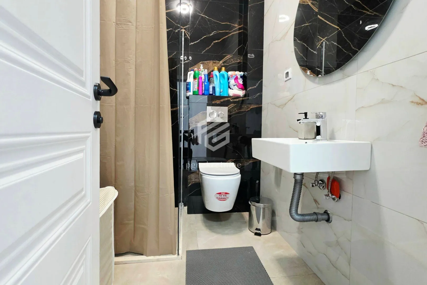 Modern bathroom with a walk-in shower, wall-hung toilet, and washbasin.