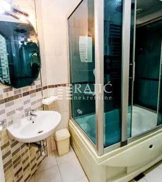 A clear bathroom with a shower cabin, washbasin, and mirror. - image 16