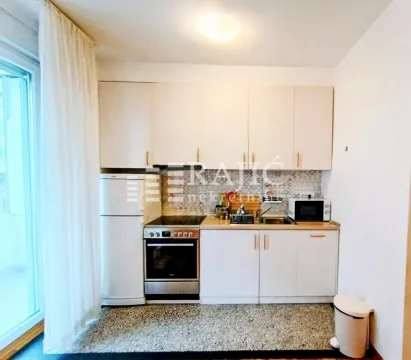 Small kitchen with white cabinets, stove and refrigerator. - image 3