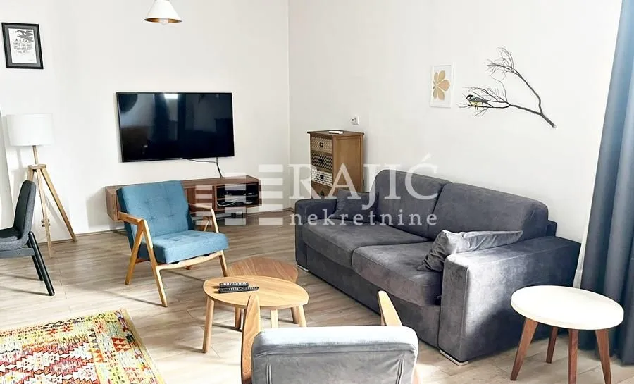 Furnished living room with a sofa, armchairs, and a TV.
