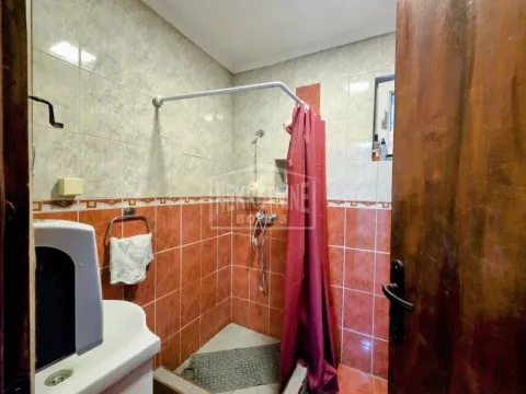 Kupatilo obloženo keramičkim pločicama sa tuš kabinom i lavaboom. - image 12