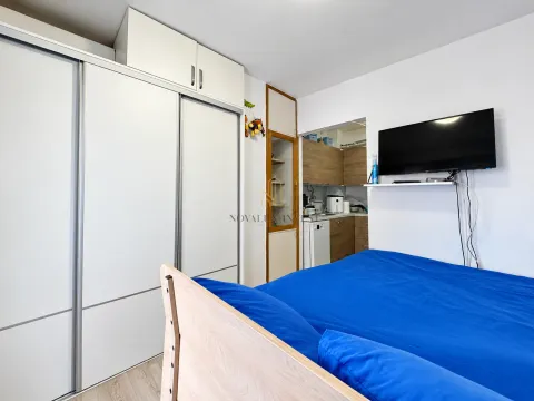 Spavaća soba sa velikim garderoberom, krevetom i zidnim televizorom. - image 6