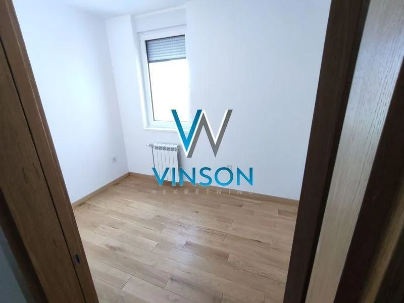 Empty room with hardwood flooring and white walls.