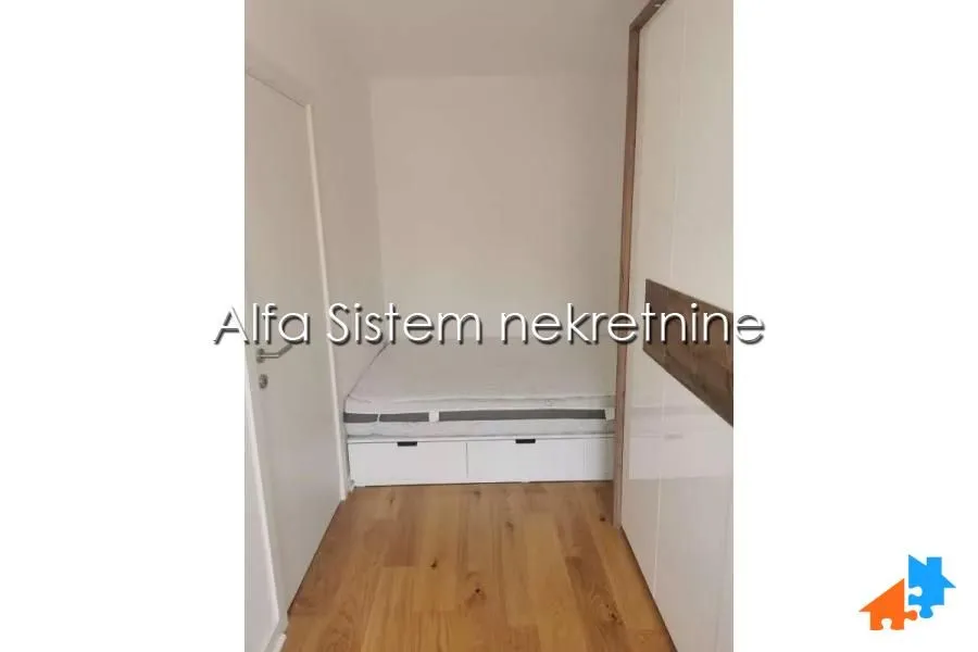 Manja spavaća soba sa krevetom i ugradnim garderoberom.