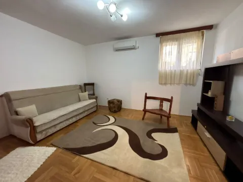 Dnevna soba sa garniturom za sedenje, tepihom i TV komodom. - image 7