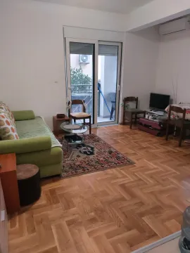 Living room with sofa, parquet flooring, and terrace access. - image 9