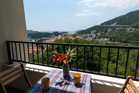 Furnished balcony with a table, chairs, and a view of the sea and city. - image 2