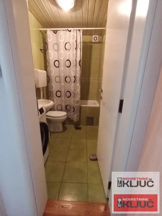 Manje kupatilo sa kadom, toaletom i mašinom za veš.