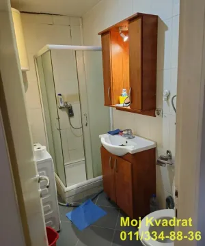Kupatilo opremljeno tuš kabinom, umivaonikom sa drvenim elementom i WC šoljom. - image 6