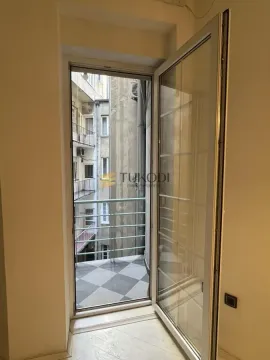 View from the balcony overlooking the inner courtyard of the building with open balcony doors. - image 19