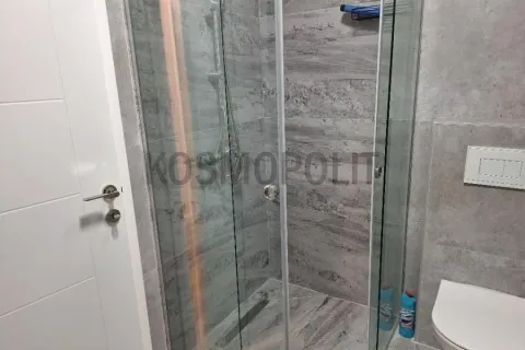 Moderno kupatilo sa tuš kabinom obloženom sivim pločicama. - image 13