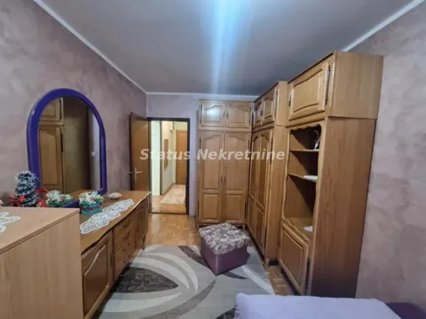 Nameštena spavaća soba sa drvenim garderoberima i komodom sa ogledalom. - image 5