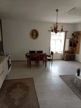 Kuhinja i trpezarija u otvorenom prostoru sa drvenim stolom i stolicama. - image 5