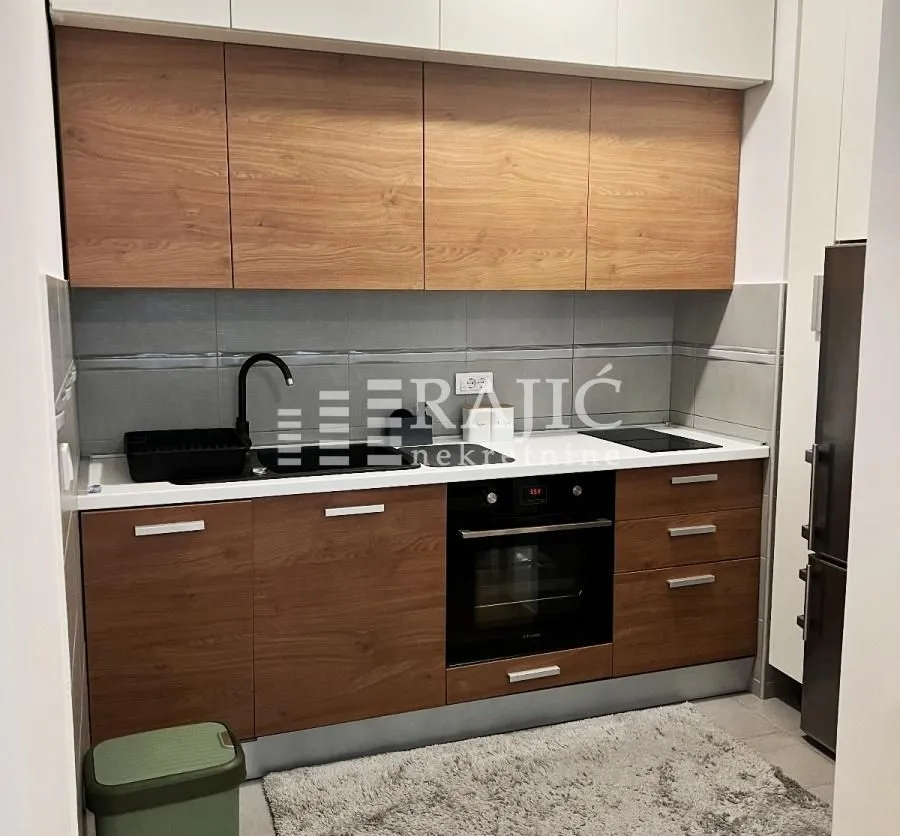Modern kitchen with wooden cabinets and built-in appliances.