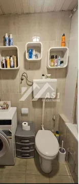 Manje kupatilo sa wc šoljom, mašinom za veš i zidnim policama. - image 9