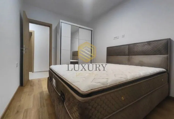 Furnished bedroom with a double bed and a wardrobe.