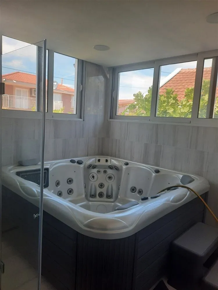Jacuzzi in a bright room with windows.