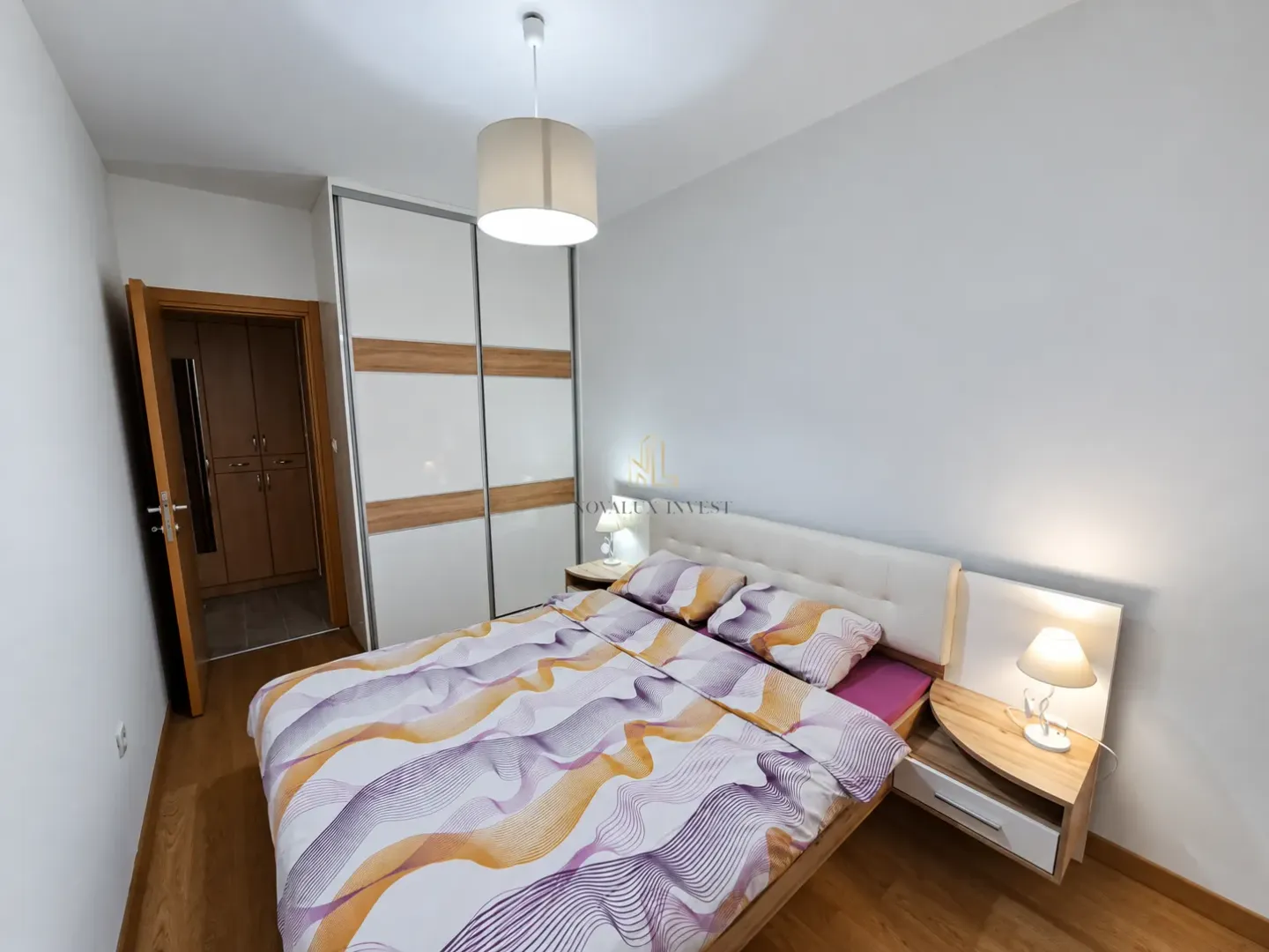 Furnished bedroom with a double bed, wardrobe, and bedside tables.