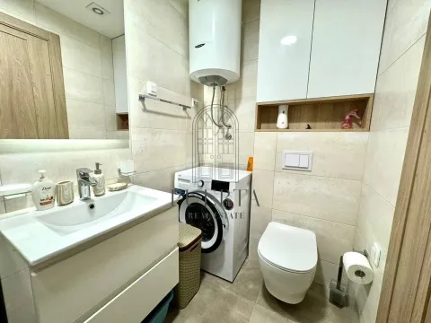Small bathroom with a sink, washing machine, toilet, and water heater. - image 13