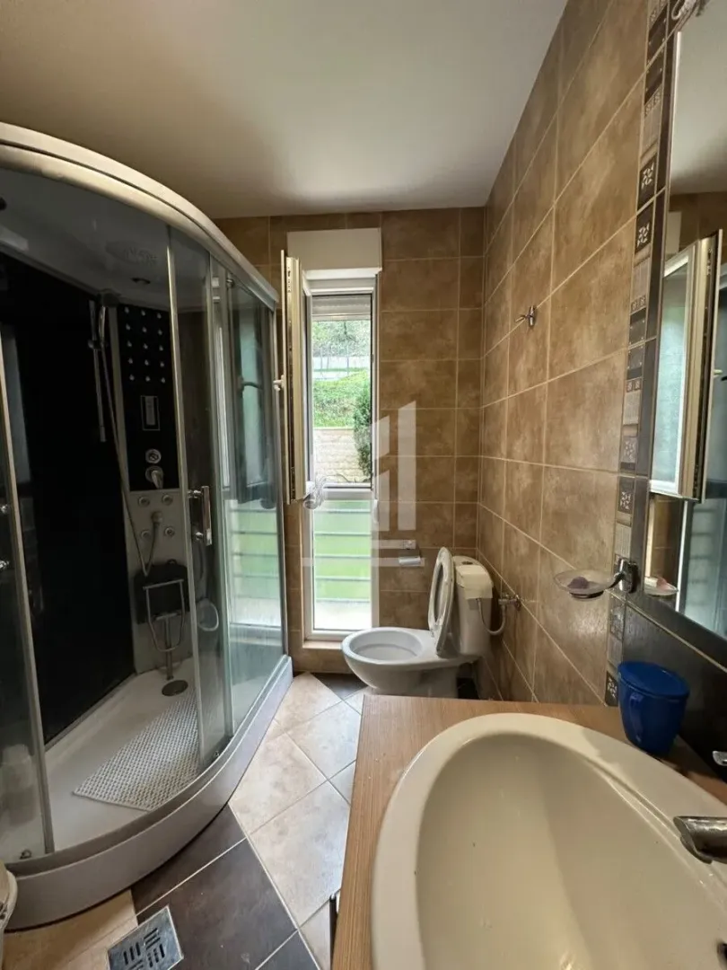 Kupatilo opremljeno tuš kabinom, umivaonikom i wc šoljom.
