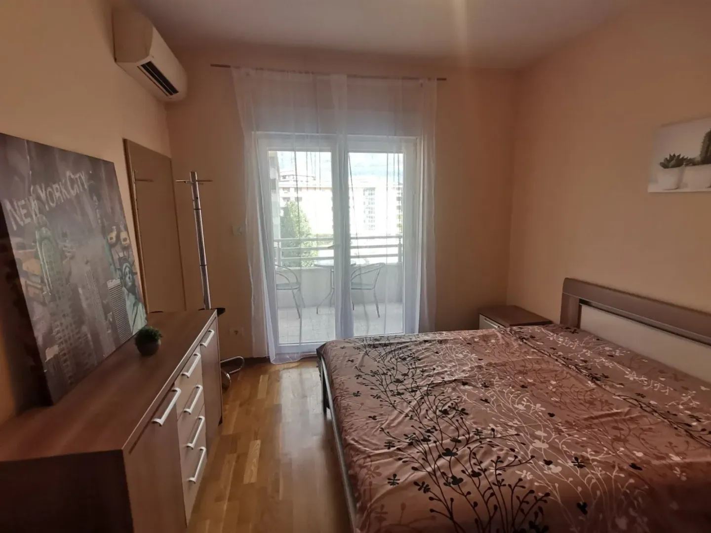 Spavaća soba sa bračnim krevetom i izlazom na balkon.