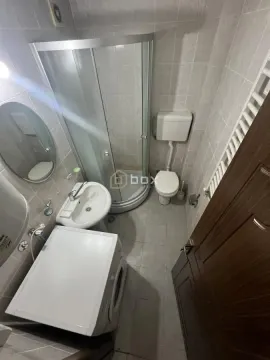 Smaller bathroom with a shower cabin, washbasin, toilet, and washing machine. - image 8