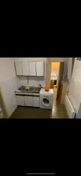 Small kitchen with a sink, cabinets, and a washing machine. - image 8