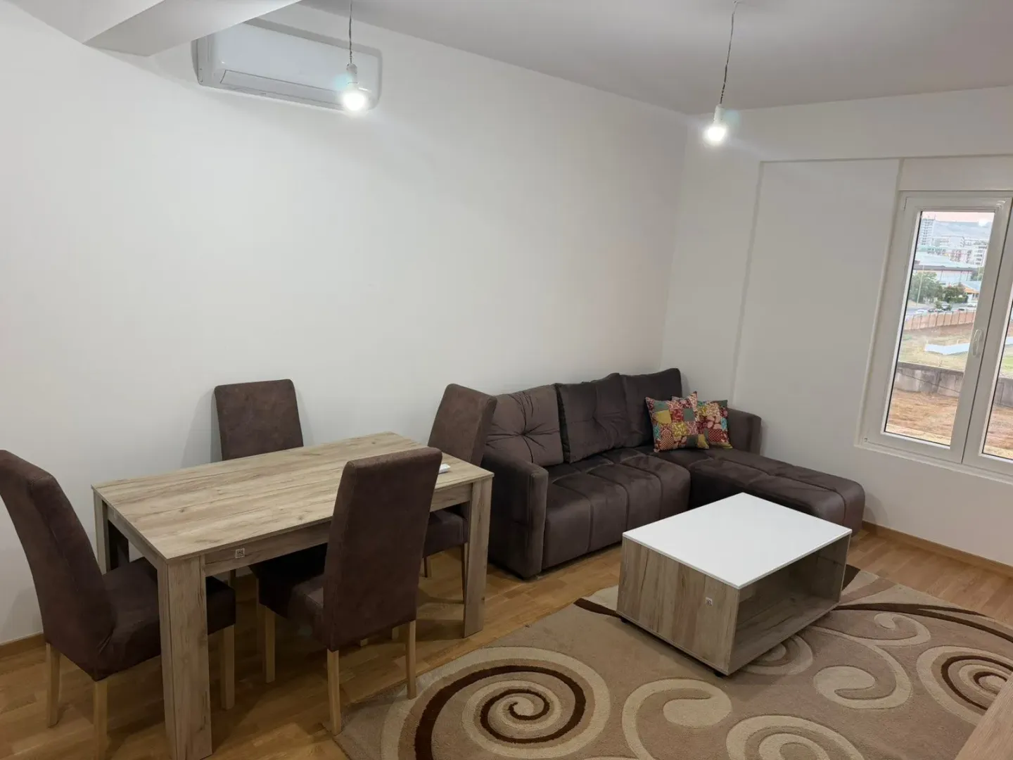 Living room with a sectional sofa, coffee table, and dining table with chairs.