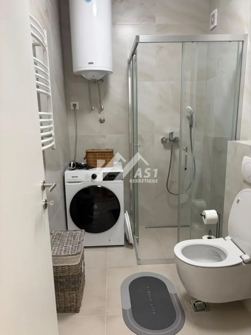 Kupatilo opremljeno tuš kabinom, wc šoljom, bojlerom i veš mašinom.