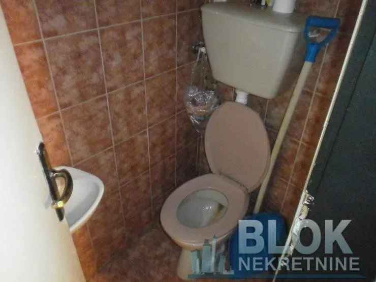 Smaller bathroom with a toilet and wall tiles.