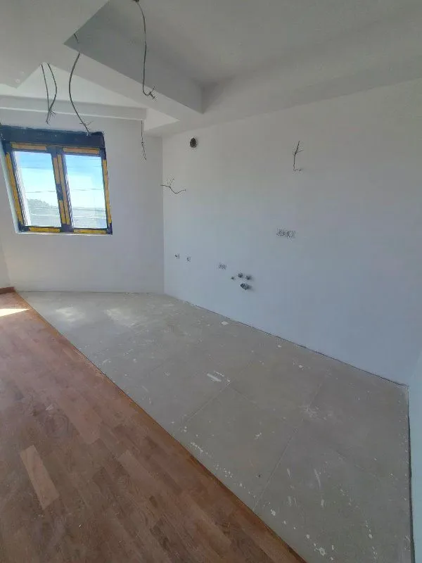 Pogled na nenamještenu prostoriju u fazi renoviranja sa pripremljenim instalacijama.