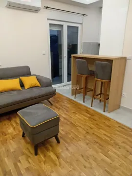 Dnevna soba sa garniturom, tabureom i šankom sa barskim stolicama. - image 4