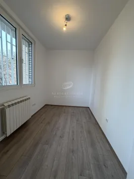 Prazna soba sa belim zidovima, laminatom i prozorom. - image 6